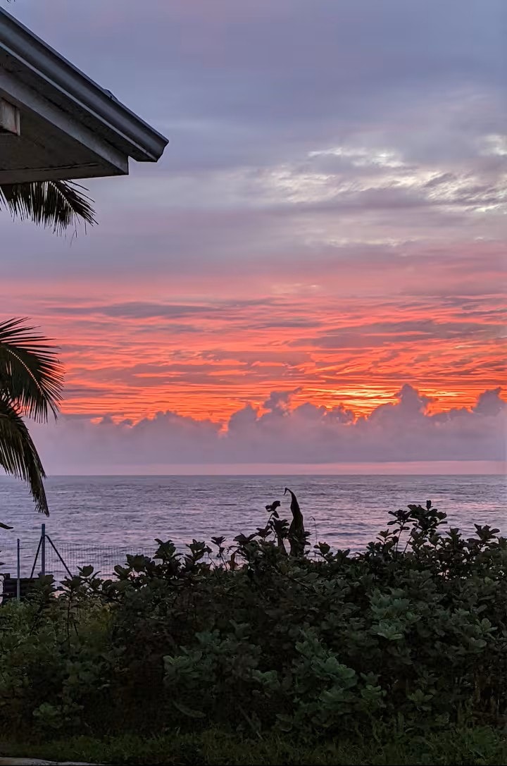 Blazing pink and orange sunset sky over the Pacific Ocean viewed from the property lanai